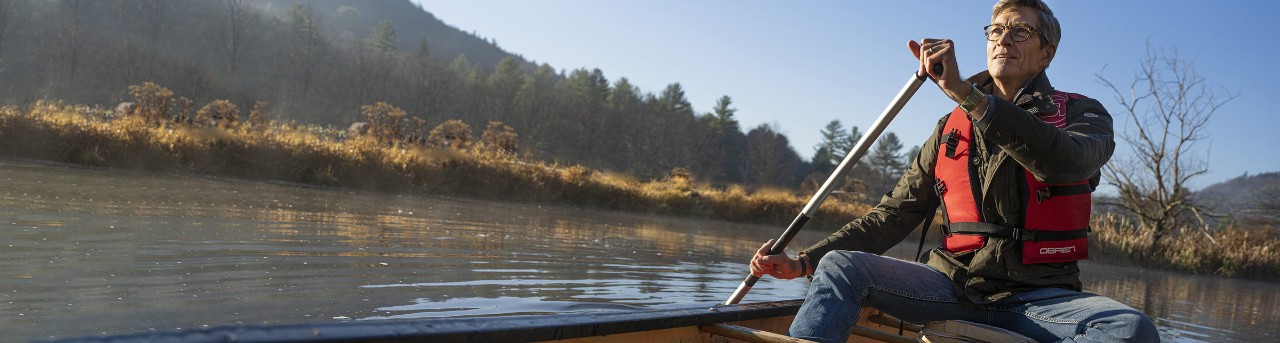 Man rowing on a lake in a canoe